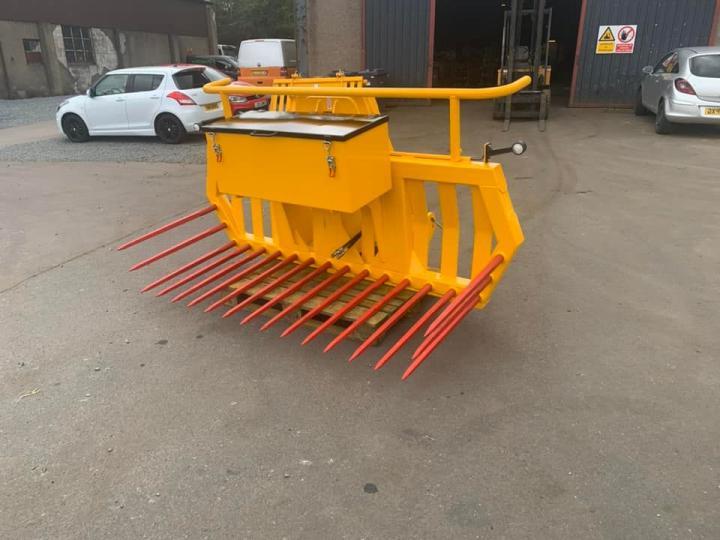 Hydraulic tipping stone fork with tool/weight box